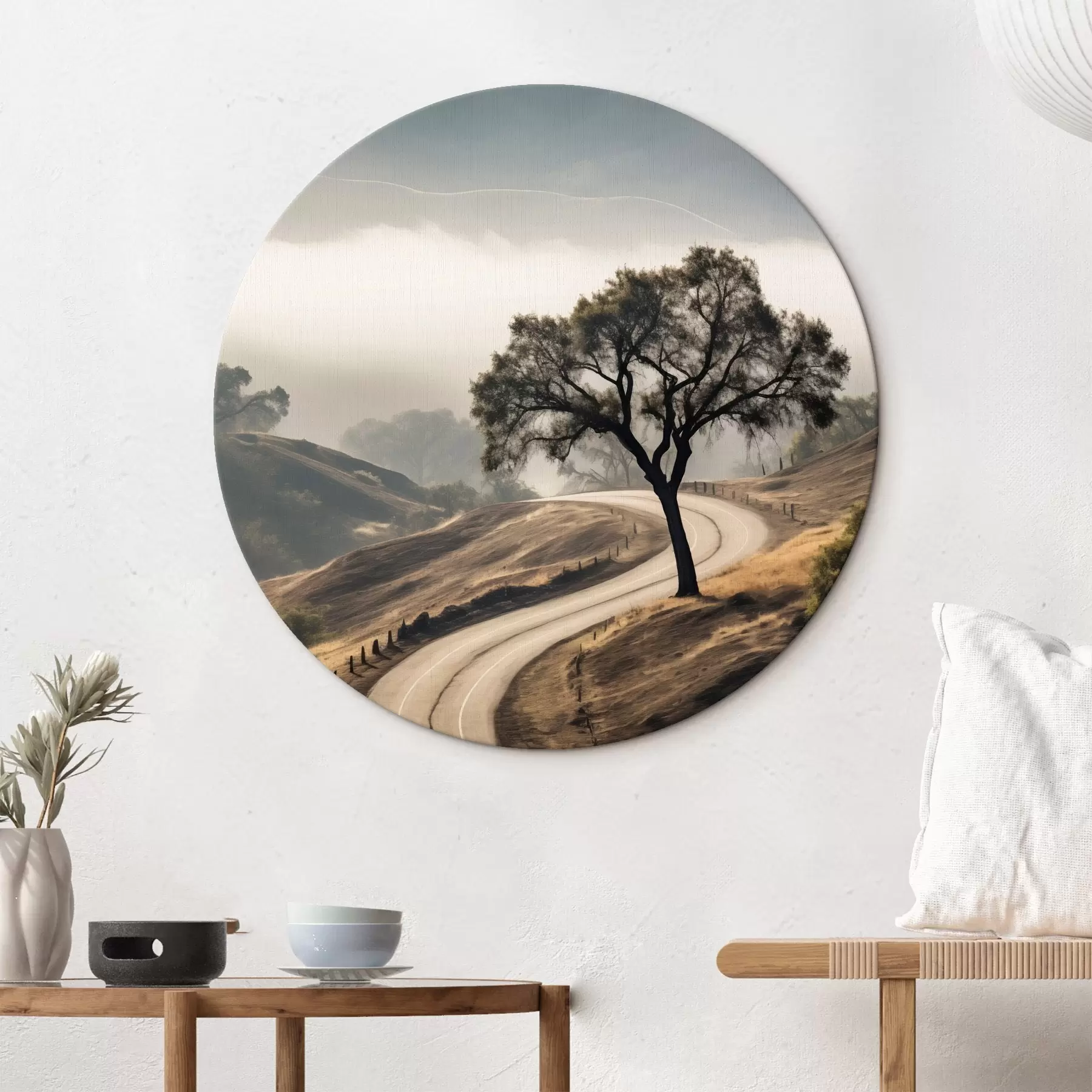 Fototapete Eine kurvenreiche Straße durch sanfte Hügel mit einem Baum im Vordergrund, im Hintergrund Nebel und Berge r46288