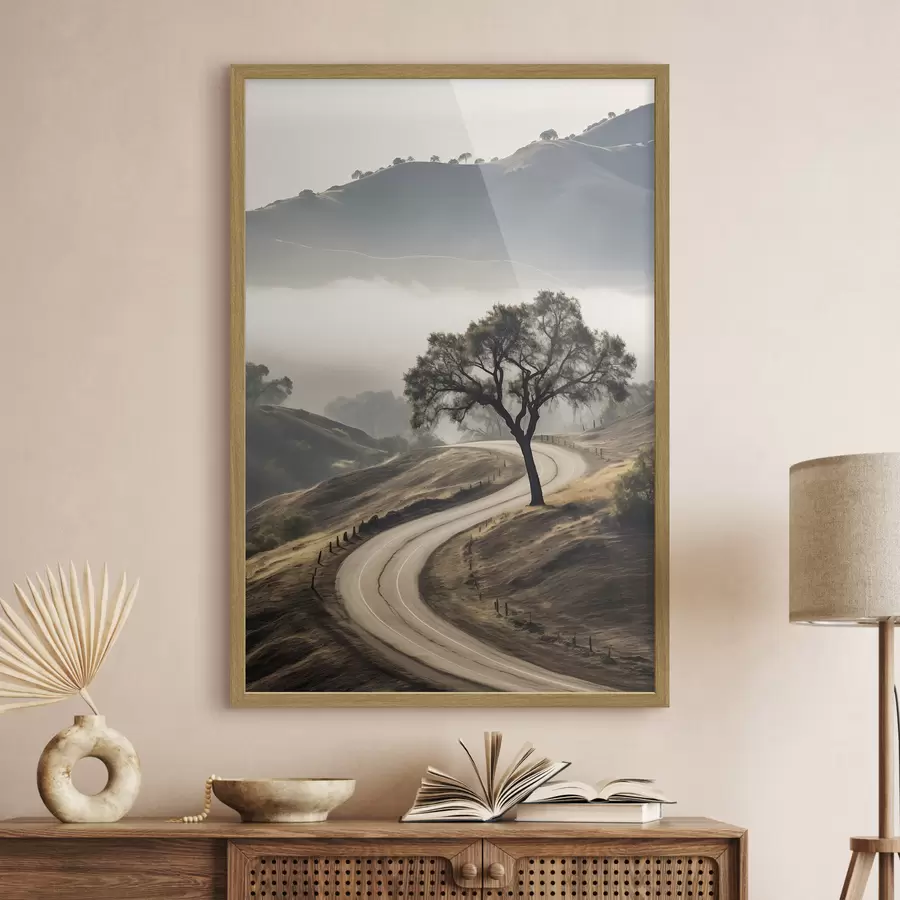 Fototapete Eine kurvenreiche Straße durch sanfte Hügel mit einem Baum im Vordergrund, im Hintergrund Nebel und Berge f46288