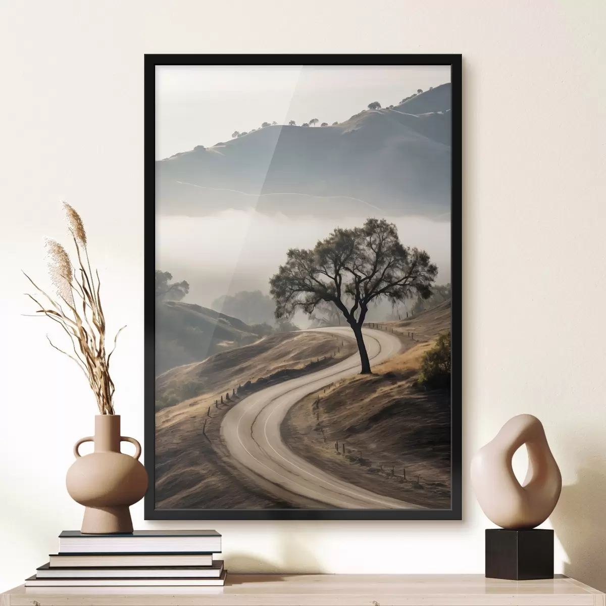Poster Eine kurvenreiche Straße durch sanfte Hügel mit einem Baum im Vordergrund, im Hintergrund Nebel und Berge f46288